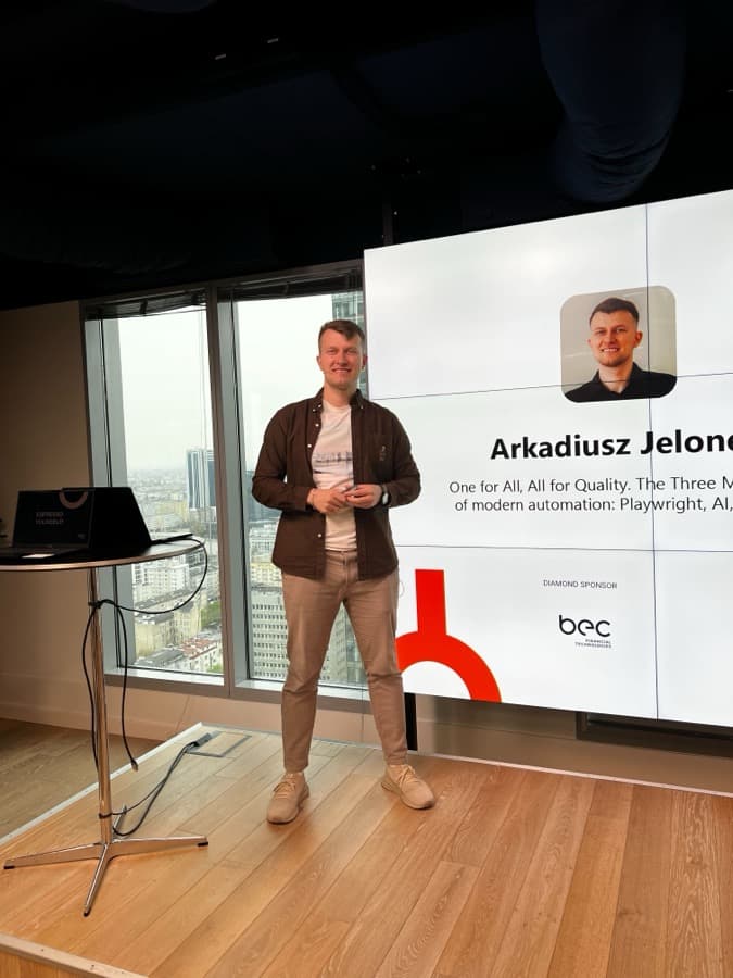 Arkadiusz Jelonek na scenie obok ekranu z tytułem swojej prelekcji